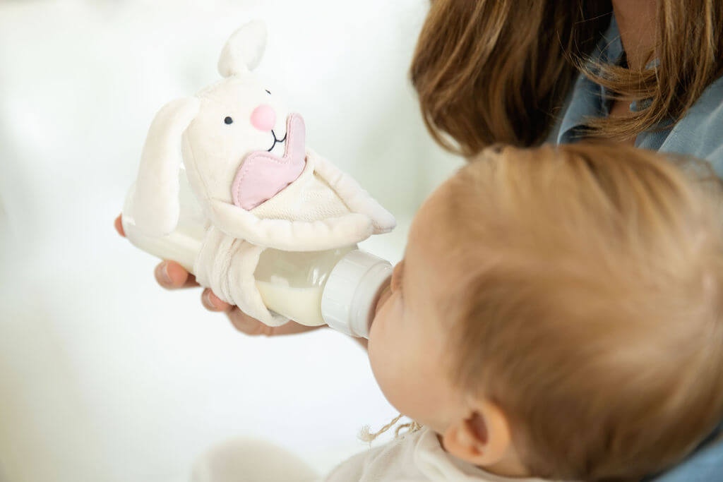 A bottle-lovey on a bottle while baby is drinking milk.